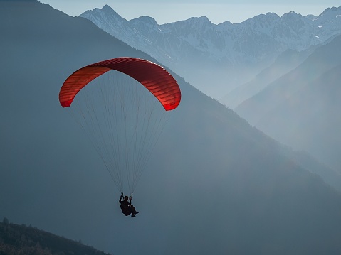 Red paragliding on a mountain background