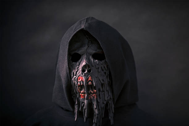 istock Scary figure in hooded cloak with mask 1255936204