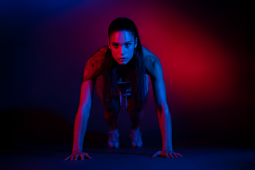 Studio shot of a young sportswoman doing push-ups.