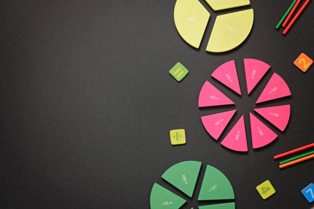 istock Mathematics background - fractions on black table, close up. Dividing fractions, math concept. 1255941728