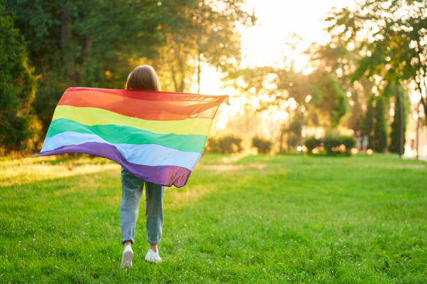 istock Woman holding rainbow lgbt flag behind back. 1255941769
