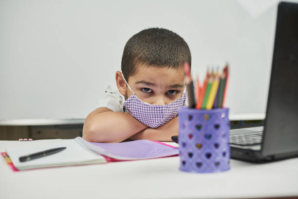 オンラインクラスから退屈な男子生徒。学校に戻る。宿題にうんざり - learning boredom studying child ストックフォトと画像