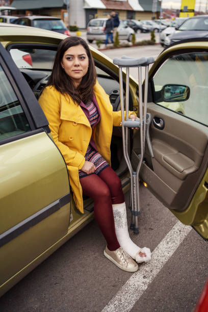 istock Woman with cast getting out of car 1255946974
