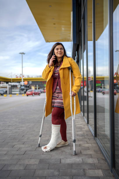 istock Woman with plaster foot talking on phone 1255948030