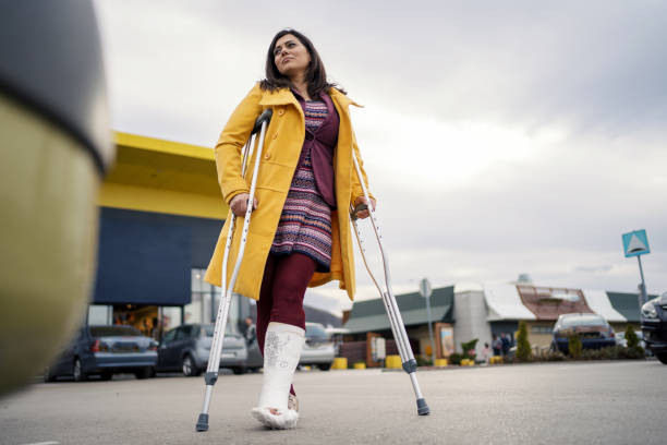 istock Woman with cast on foot walking with crutches 1255948044