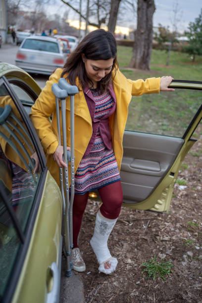 istock Woman with cast getting out of car 1255948100
