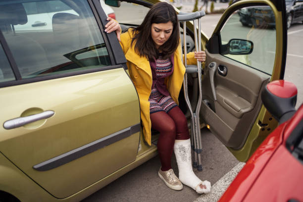istock Woman with cast getting out of car 1255948117