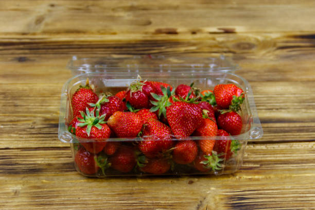 istock Fresh strawberry in plastic box on a wooden table 1255948911