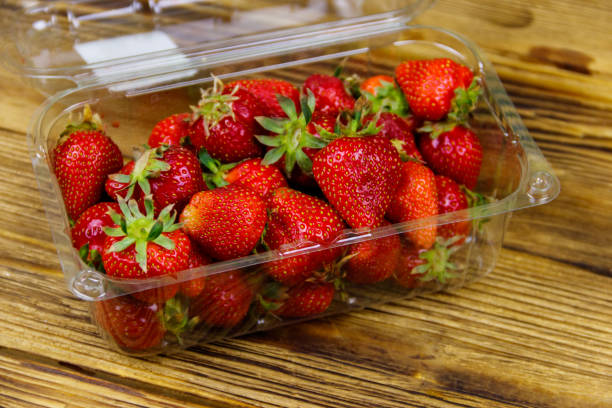 istock Fresh strawberry in plastic box on a wooden table 1255948912