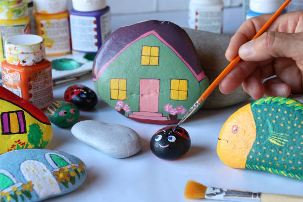 istock hand painting eyes of stylized ladybug on a stone 1255948973