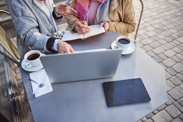 istock Women with pencil and red notebook doing home work at the terrace cafe 1255953733