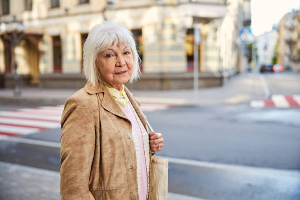 istock Middle age woman going through the city and smiling 1255953978