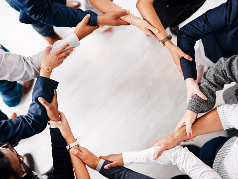 Closeup shot of a group of unrecognisable businesspeople forming a circle with their hands