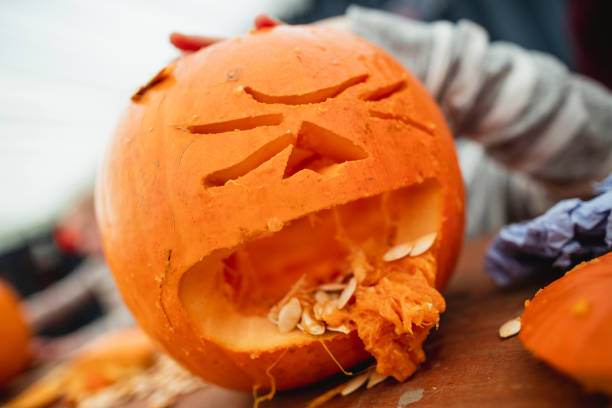 Spooky Pumpkin Carved pumpkin ready for halloween that has a funny face designed to look like it's throwing up pumpkin seeds. throwing up pumpkin stock pictures, royalty-free photos & images