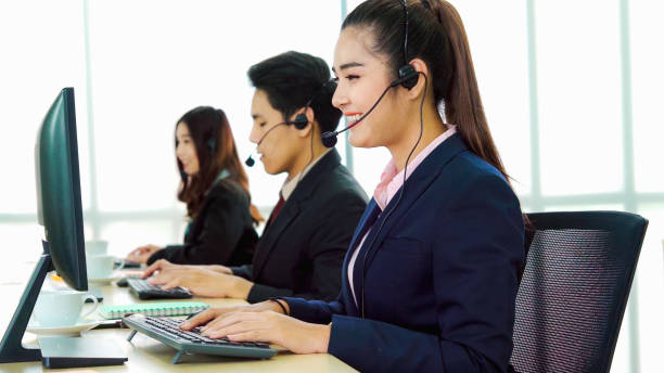 istock Business people wearing headset working in office 1255955572