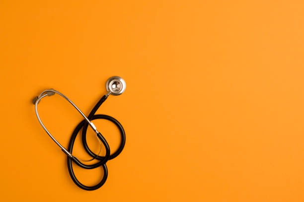 istock Covid-19 Coronavirus concept. Stethoscope medicine accessory, orange background with copy space. top view 1255955869