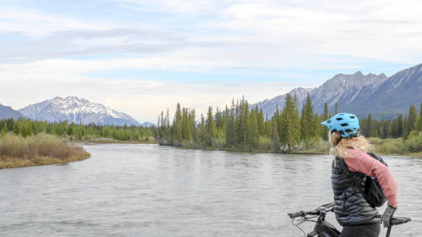 istock Female mountain e-biker relaxes by lakeshore 1255959160