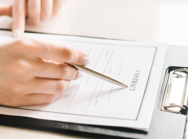 istock Girl sits at a table and signs a contract. Business 1255960968
