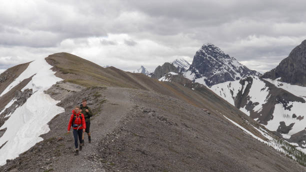 istock Young mountaineering couple walk along mountain ridge 1255962268