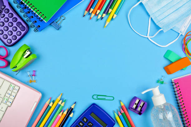 istock School supplies and COVID 19 prevention frame on a blue paper background 1255962617