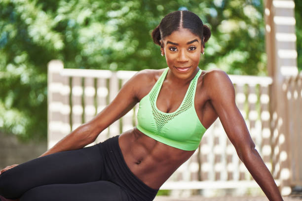 african american woman wearing workout clothes posing on backyard deck during the day