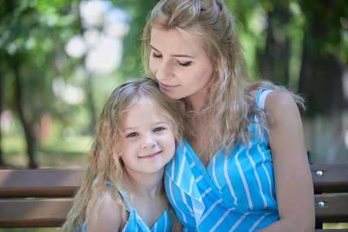 Portrait of happy woman and girl with long and blond hair.