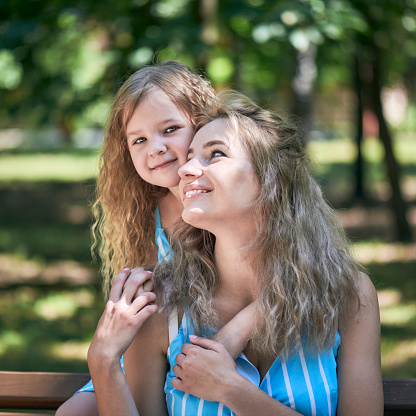 Portrait of happy woman and girl with long and blond hair.