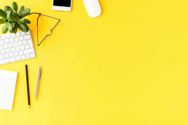 istock Elegant office desktop with business accessories on yellow background with copyspace. Top view 1255965663