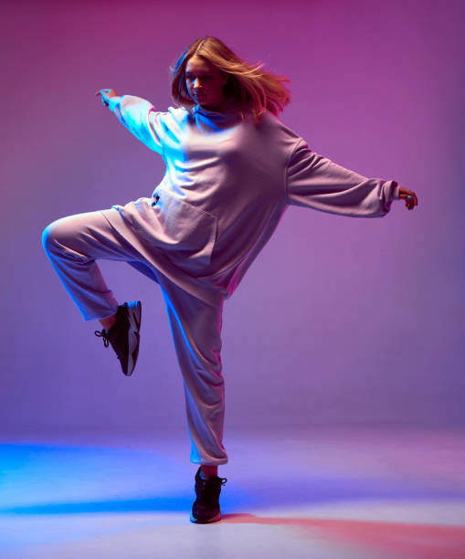 세련된 어린 소녀, 네온 배경에, 개발 머리와 후드에서 멋진 춤. 댄스 스쿨 포스터 - dancing dancer hip hop jumping 뉴스 사진 이미지