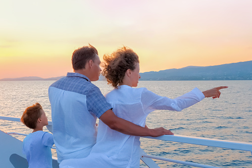 Happy family travels by sea. Family tourism concept. Consumers pinpoint travel. Voyage to Greece. Season stay, short stay of traveling. Woman in white with husband and son on yacht, boat, ship