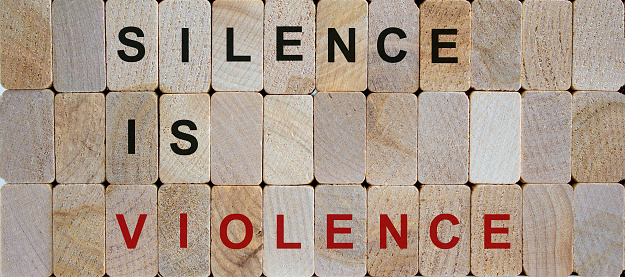 Wooden blocks form the words 'silence is violence'. Beautiful wooden background. Concept image.