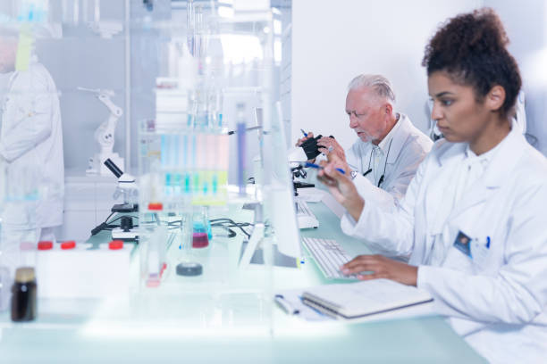 istock Multi ethnic laboratory team at work. African, female doctor making notes 1255972439