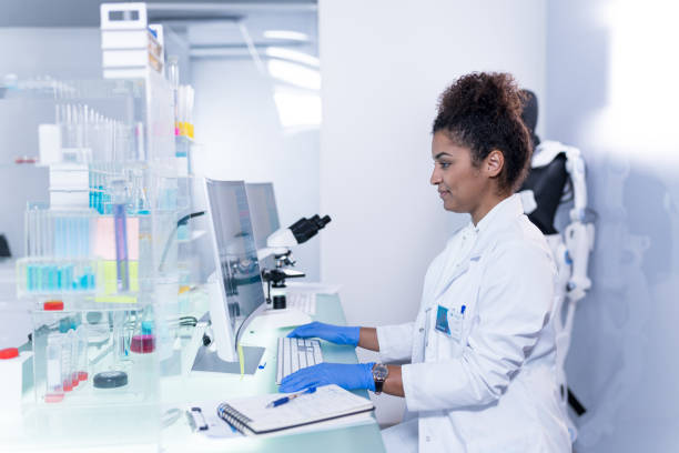 istock Laboratory worker at work. African, female doctor focused on exoskeletin project 1255974054