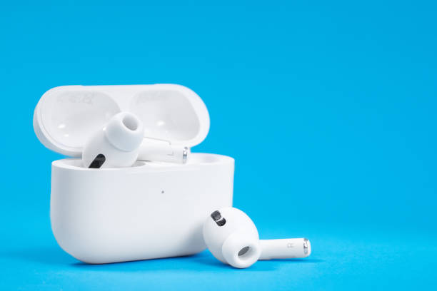 drahtlose kopfhörer apple airpods pro in geöffneten ladetasche mit aktiver geräuschunterdrückung immersiven sound, auf blauem hintergrund, kopierraum. - apple computers audio stock-fotos und bilder