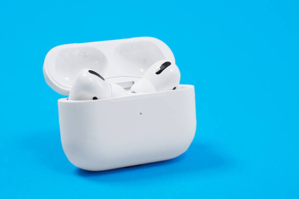 drahtlose kopfhörer apple airpods pro in geöffneten ladetasche mit aktiver geräuschunterdrückung immersiven sound, auf blauem hintergrund, kopierraum. - apple computers audio stock-fotos und bilder