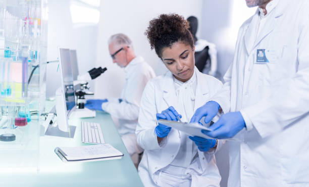 istock Multi ethnic laboratory team at work. African, female doctor consulting exoskeleton project 1255975318