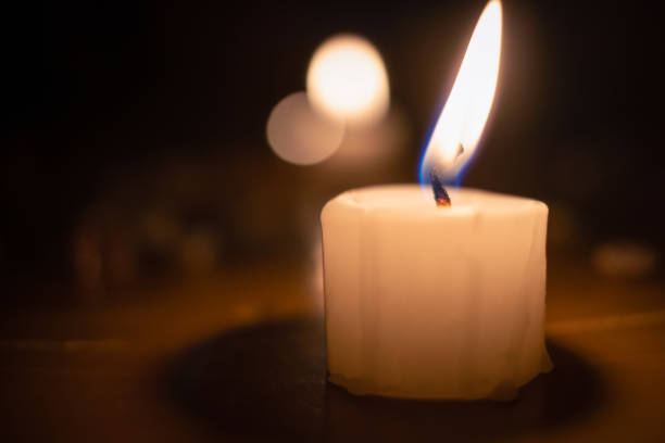 istock Large white lighted candle close-up. concept of magic, divination. 1255976336