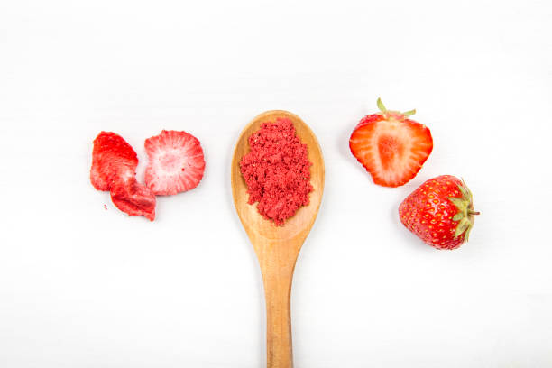 poudre de fraise faite de fraises lyophilisées pour saupoudrer. ingrédient de saveur et de couleur pour la nourriture. vue supérieure, fond minimal blanc, espace de copie. grande source de vitamine c et de fer. - dry strawberry dried food fruit photos et images de collection