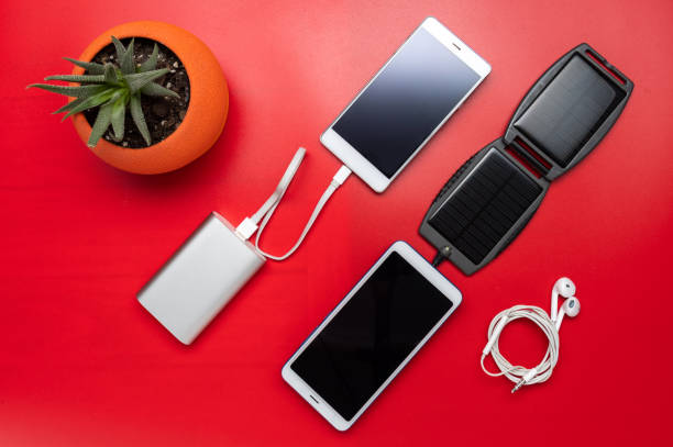 istock Electric power bank and solar panel. Charging smartphones. Flat lay. 1255980353