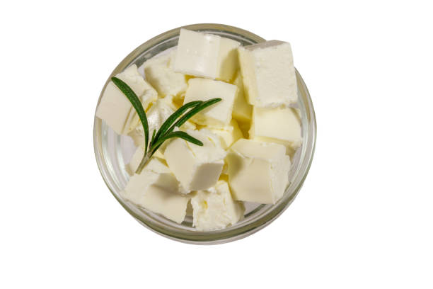 Feta cheese cubes with rosemary in glass bowl isolated on white background