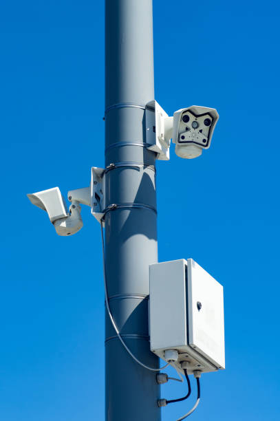 istock Surveillance cameras on a pole against a blue sky. 1255982035