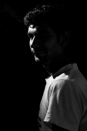 Young man thinking dramatic low key black and white portrait