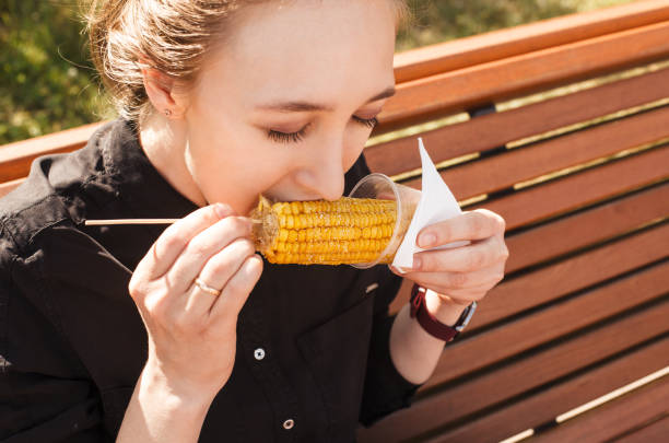 istock Girl eating corn on the cob with closed eyes closeup. 1255983449