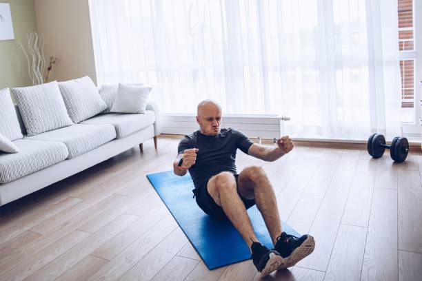 istock Home workout. Man exercising and doing sit-up crunches at home. 1255984083