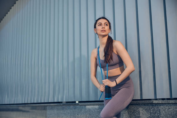 istock Pretty woman with a jump rope looking away 1255984219