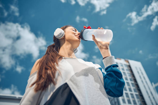 istock Young dark-haired woman holding a plastic bottle 1255984250