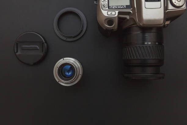 istock Photographer workplace with dslr camera system and lens on dark black table background. Hobby travel photography concept. Flat lay top view copy space 1255985668