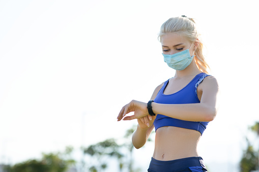 Young female athlete is wearing a surgical mask