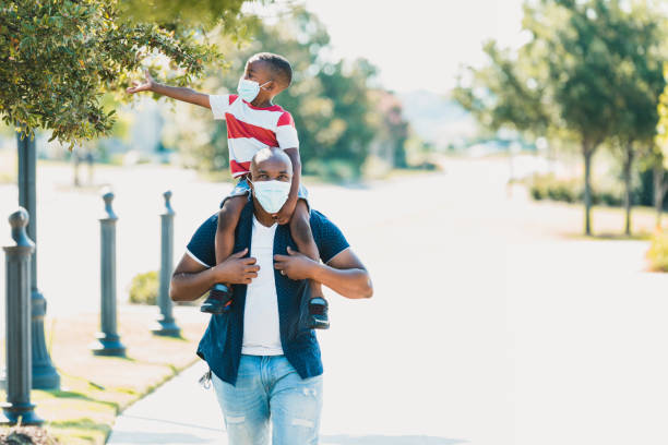 istock Son, riding piggy back, reaches out for tree 1255989089