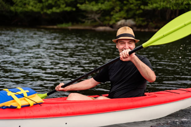 istock 50 + man kayaking on a lake. 1255993065